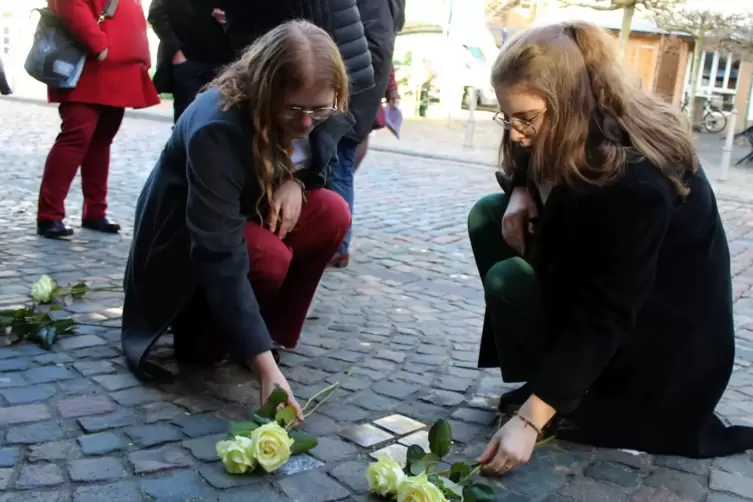  Angelina Fritz (links) und Sarah Kriese legen weiße Rosen zur Erinnerung an Familie Spiegel an der Lauterecker Schlossapotheke 