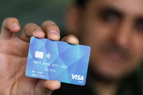 Ein Geflüchteter hält eine Debitcard in der Hand. Die Karte soll bundesweit eingeführt werden. 