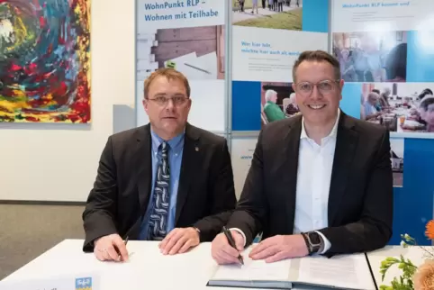 Thomas Jaworek, Bürgermeister von Kallstadt, und Minister Alexander Schweitzer unterschreiben eine Kooperationsvereinbarung, die