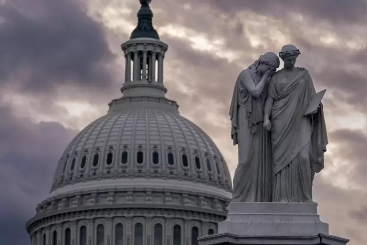 Blick auf das Friedensdenkmal und die Kuppel des US-Kapitols bei bewölktem Himmel.