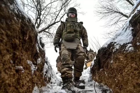 Ein Soldat einer ukrainischen Artilleriebrigade steigt in einen Schützengraben in der südukrainischen Region Saporischschja hina