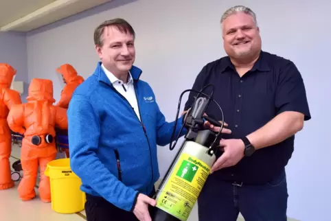 Daniel Frambach, Leiter der BASF-Ambulanzen (links), übergibt ein neues Dekontaminationsgerät an Michael Kreinest, Leiter Stabss