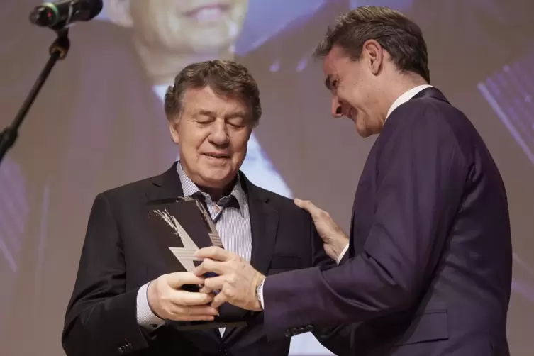 Otto Rehhagel (l) erhält vom griechischen Ministerpräsidenten Kyriakos Mitsotakis eine Auszeichnung für sein Lebenswerk des grie