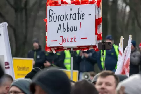 Schild mit der Aufschrift „Bürokratie-Abbau! Jetzt“, hochgehalten von Landwirten bei einer Kundgebung in Berlin. Dass der Stando
