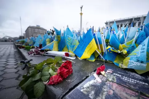 Rosen und ukrainische Fahnen für gefallene Soldaten und zivile Opfer der russischen Invasion in der Ukraine liegen auf dem Unabh