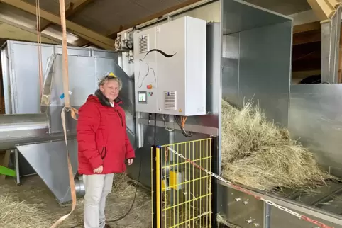 Frank Orth vor der Entstaubungsanlage: Das eingeführte Heu wird im Gehäuse aufgewirbelt, Partikel werden über das Rohr links abg