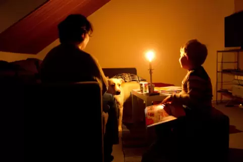 Eine Kerze beleuchtet ein Zimmer, in dem eine Mutter und ihr Sohn leben. 