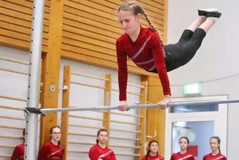 Mit viel Schwung: Charlotte Clemens von der Realschule Plus Lauterecken/Wolfstein am Reck – und die Teamkolleginnen fiebern mit.