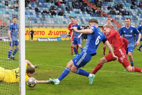 Yannick Grieß schiebt zum 1:0 ein. Pfeddersheims Torhüter Sören Pätzold und Marco Bresser kommen zu spät. Im Hintergrund in Blau