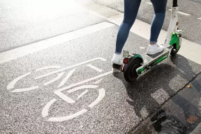 Eine Person fährt mit einem E-Roller auf einem Radweg