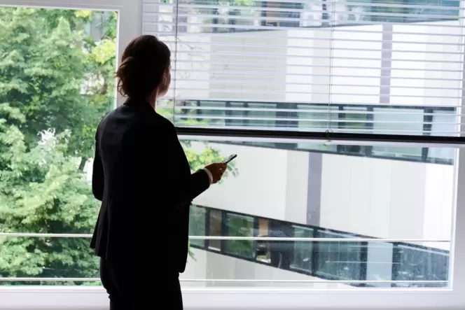 Eine Frau steht in einem Büro am Fenster