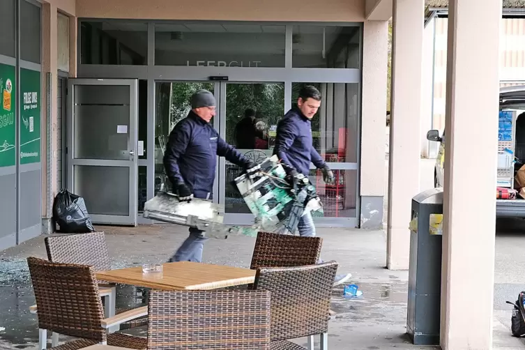 Mitarbeiter der VR-Bank tragen Reste des gesprengten Geldautomaten aus dem Contwiger Wasgau-Markt. r