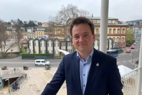 Constantin Beck-Burak auf dem Balkon an seinem Büro. Im Hintergrund ist der Saalbau zu sehen. 