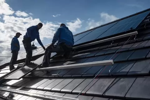 Mitarbeiter einer Photovoltaikanlagen-Firma installieren Module auf ein Dach: Die Branche befindet sich in ständigem Wandel. 