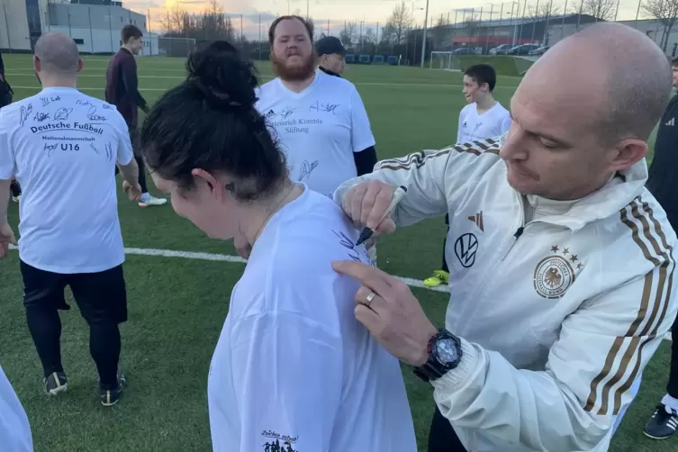Gab gerne Autogramme: U16-Nationaltrainer Marc-Patrick Meister, hier mit einer Fu&szlig;ballerin der Kimmle-Stiftung. 