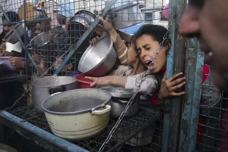 Palästinenser stehen in einem Flüchtlingslager im Gazastreifen an, um kostenlose Mahlzeiten zu erhalten.