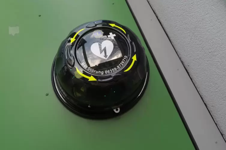 So sieht der Defibrillator in Gr&uuml;nstadt, der in einem runden Geh&auml;use steckt, aus der N&auml;he aus.