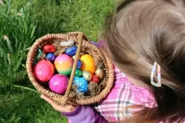 Ein Kind sammelt bunte Ostereier