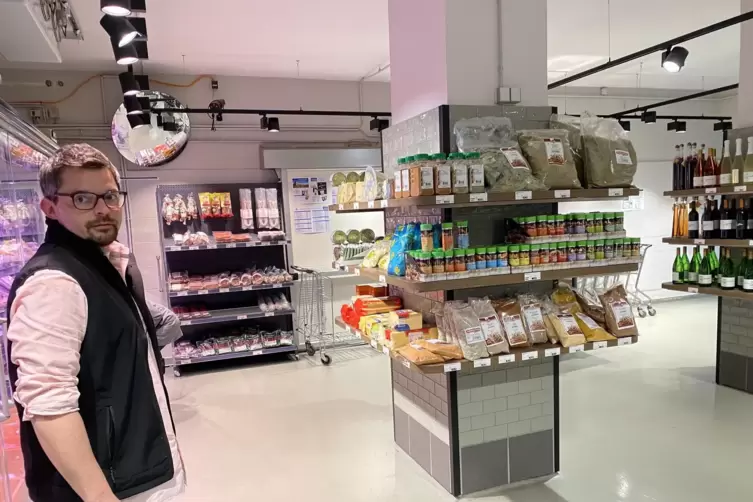 Tim Conrad vor einem Verkaufsregal mit Gew&uuml;rzen und Nudelprodukten. 