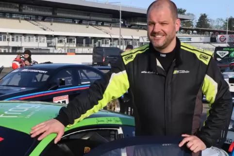 Rennfahrer Jochen Stoll neben seinem neuen Wettbewerbsfahrzeug, einem Porsche 911.2 GT 3 Cup.