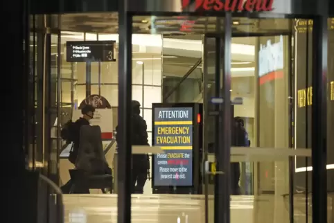 Polizisten bei einem Hinweisschild zur Evakuierung des Westfield-Einkaufszentrums in Sydney. 