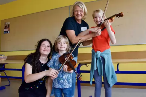 So geht’s: Geigen-Schülerin Sarah zeigt Mats (vier), wie man eine Geige hält, Lehrerin Hiltrud Wies kümmert sich um Maja (zehn).