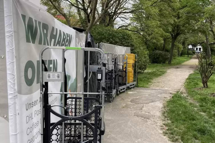 Streitobjekte: Rollwagen f&uuml;r Pakete stehen neben dem Kiosk auf einem Fu&szlig;weg. 