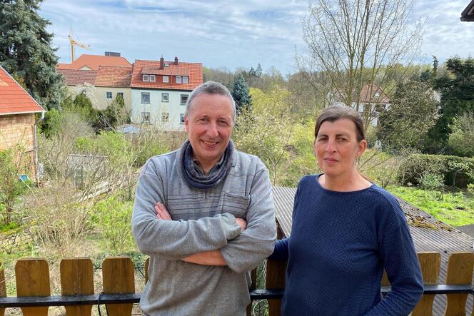 Stefan und Andrea Nitsche auf ihrem Balkon über den verwilderten, offenen Gärten hinter ihrem Haus am Seebacher Ortsrand.