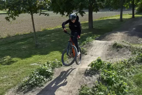 Ein Mountain-Biker auf einer Pumptrack-Strecke.