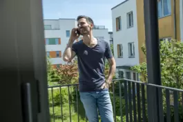 Ein Mann telefoniert auf einem Balkon