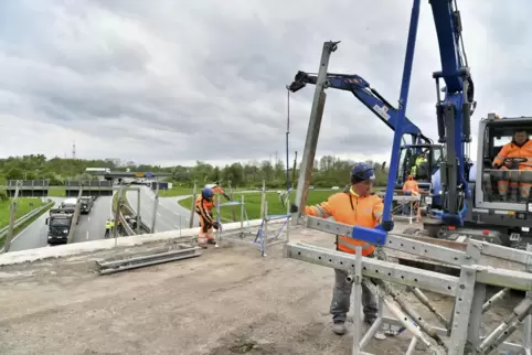Die Arbeiter bauen ein Traggerüst ab, das benötigt wurde, um die Betonkappen zu beseitigen. 