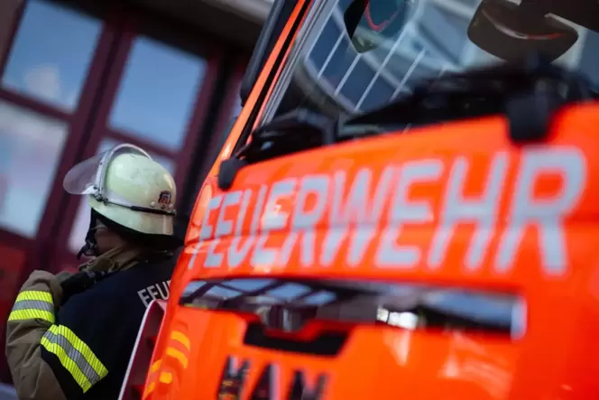 Ein Feuerwehrmann steht neben einem Einsatzfahrzeug