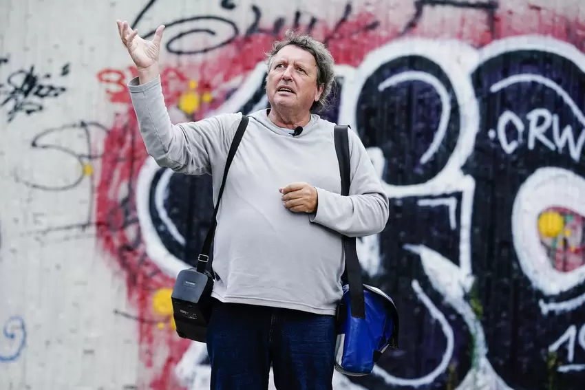 Humor statt Häme: Helmut van der Buchholz bei einer Stadtführung im September 2021 vor einer Wand mit Graffiti.