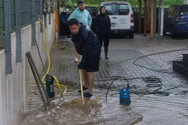 Anwohner Ali Aslani reinigt seinen Hof. Eine Kellerwohnung in seinem Haus wurde ebenfalls durch das Wasser stark beschädigt