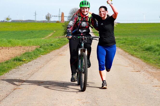 Die Initiatorin des Hawethon Viktoria Meyer, begleitet auf dem Mountainbike von ihrer Schwester Friederike, joggt am Monolith be