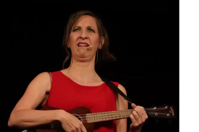 Sarah Hakenberg singt mit mürrischem Gesichtsausdruck eines ihrer Lieder zur Ukulele.