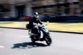 Ein Motorrollerfahrer auf einer Straße in Berlin