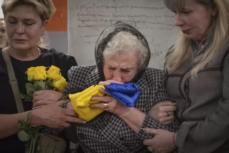 Trauerfeier in Kiew am 6. Mai: Die Mutter eines gefallenen ukrainischen Soldaten k&uuml;sst die Fahne, die den Sarg ihres Sohnes bede