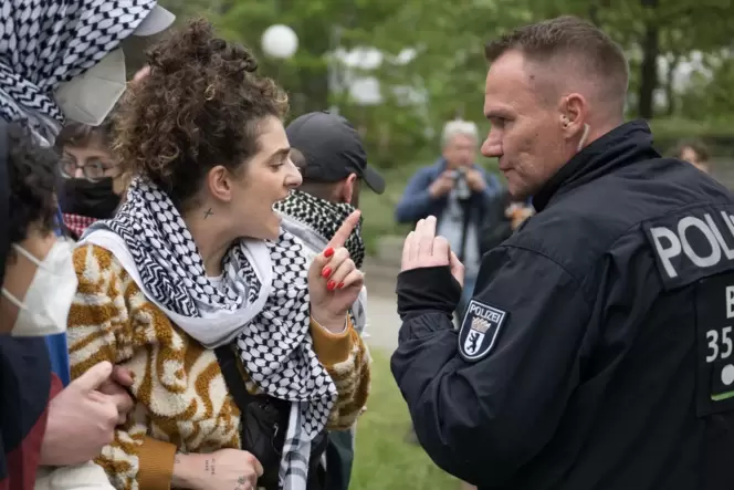 Wenigstens wird hier noch diskutiert: Debatte zwischen einer Demonstrantin und einem Polizisten während einer pro-palästinensisc