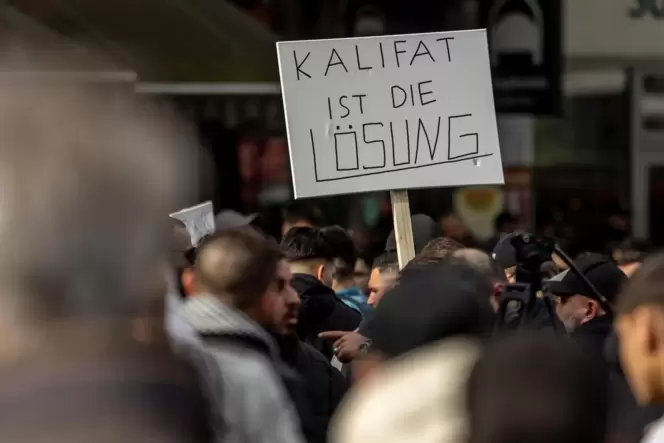 27. April in Hamburg: Teilnehmer einer Islamisten-Demo halten ein Plakat mit der Aufschrift »Kalifat ist die Lösung« in die Höhe