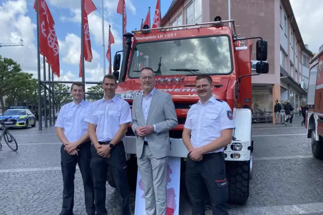 Maik Matheis, Carsten Clauer, Innenminister Michael Ebling und Simon Tigges vor dem neuen Feuerwehrfahrzeug.
