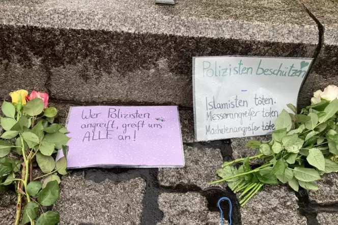 Blumen und handgeschriebene Zettel liegen am Reiterdenkmal auf dem Mannheimer Marktplatz.