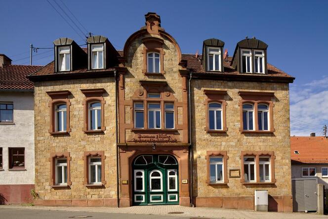Das Vorderhaus trägt noch den Firmenschriftzug der 1903 gegründeten Drahtwarenmanufaktur Baumann & Müller in Walsheim.