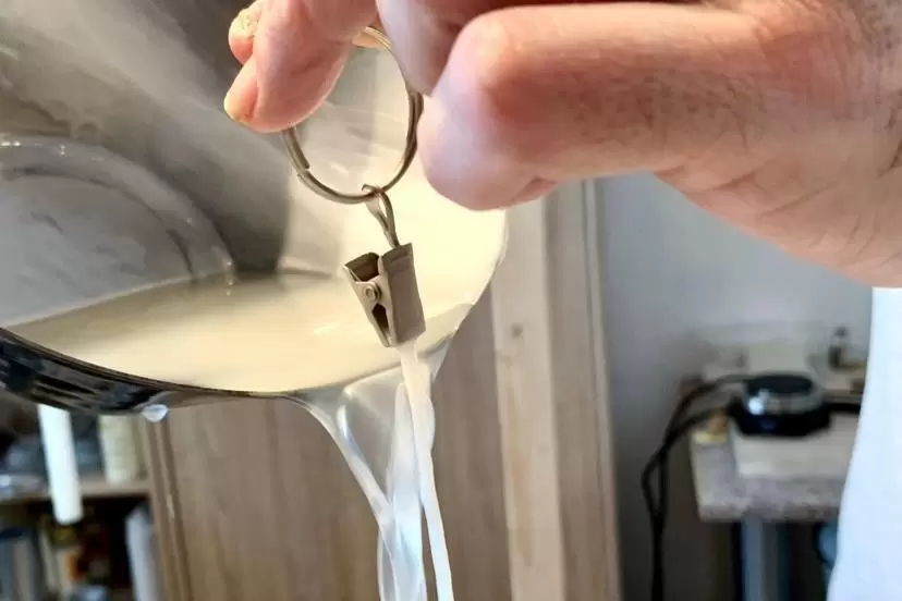 Der Docht wird mit Wachs begossen.