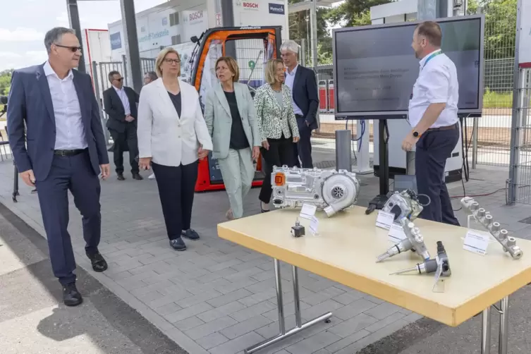 Anke Rehlinger (links) und Malu Dreyer (daneben) schauen sich die Wasserstoff-Motorenteile an, die bei Bosch schon in mehreren G