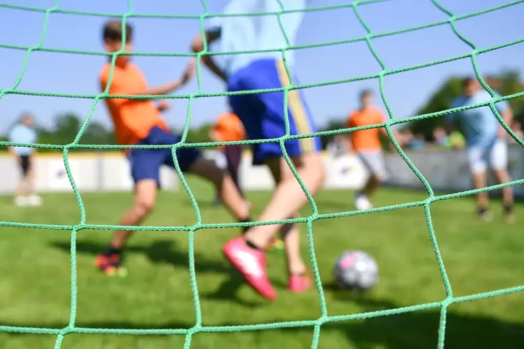 Kinder spielen Fußball auf einem Sportplatz