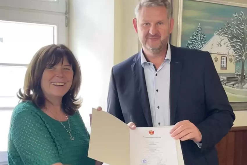 OB Jutta Steinruck händigt Andreas Olbert die Urkunde als Ehrenbeamter aus.