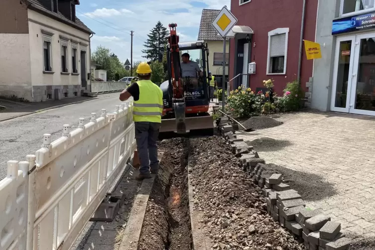 Mit dem Kleinbagger ziehen die M&auml;nner einen Graben in den B&uuml;rgersteig. Hier vor dem Heizungs- und Sanit&auml;rgesch&auml;ft von Markus Sch