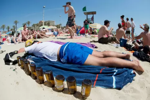Der Typ Ballermann: Ein deutscher Tourist liegt schlafend am Strand von Arenal auf Mallorca. Man beachte die Bierflaschen rund u