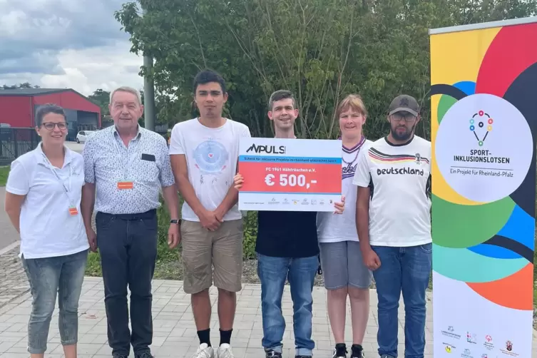 Der Fu&szlig;ballverein FC H&ouml;hfr&ouml;schen mit dem Vorsitzenden Heinrich Klein (Zweiter von links) bekommt von der Inklusionslotsin Sabrin
